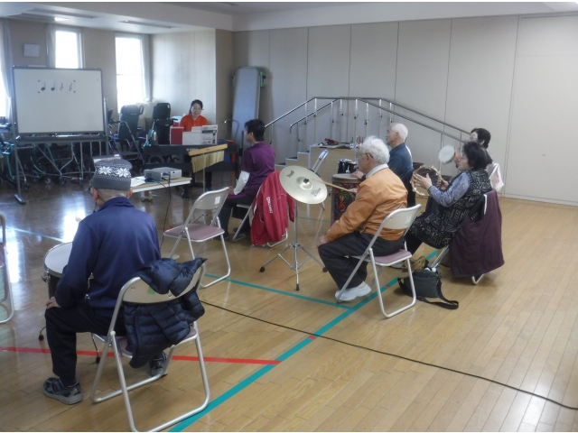 音楽療法士による楽器を用いた体操の様子です