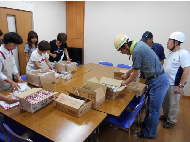 炊き出し班は災害用の非常食を人数分によそい、袋詰めします。