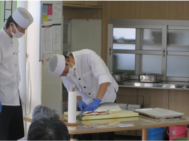大きな包丁で3枚におろしています。