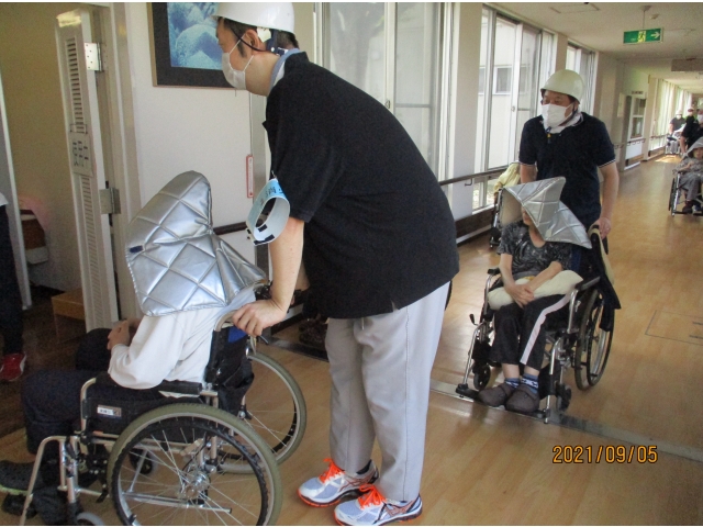 利用者さまは防災頭巾をかぶり、職員の誘導でしました。